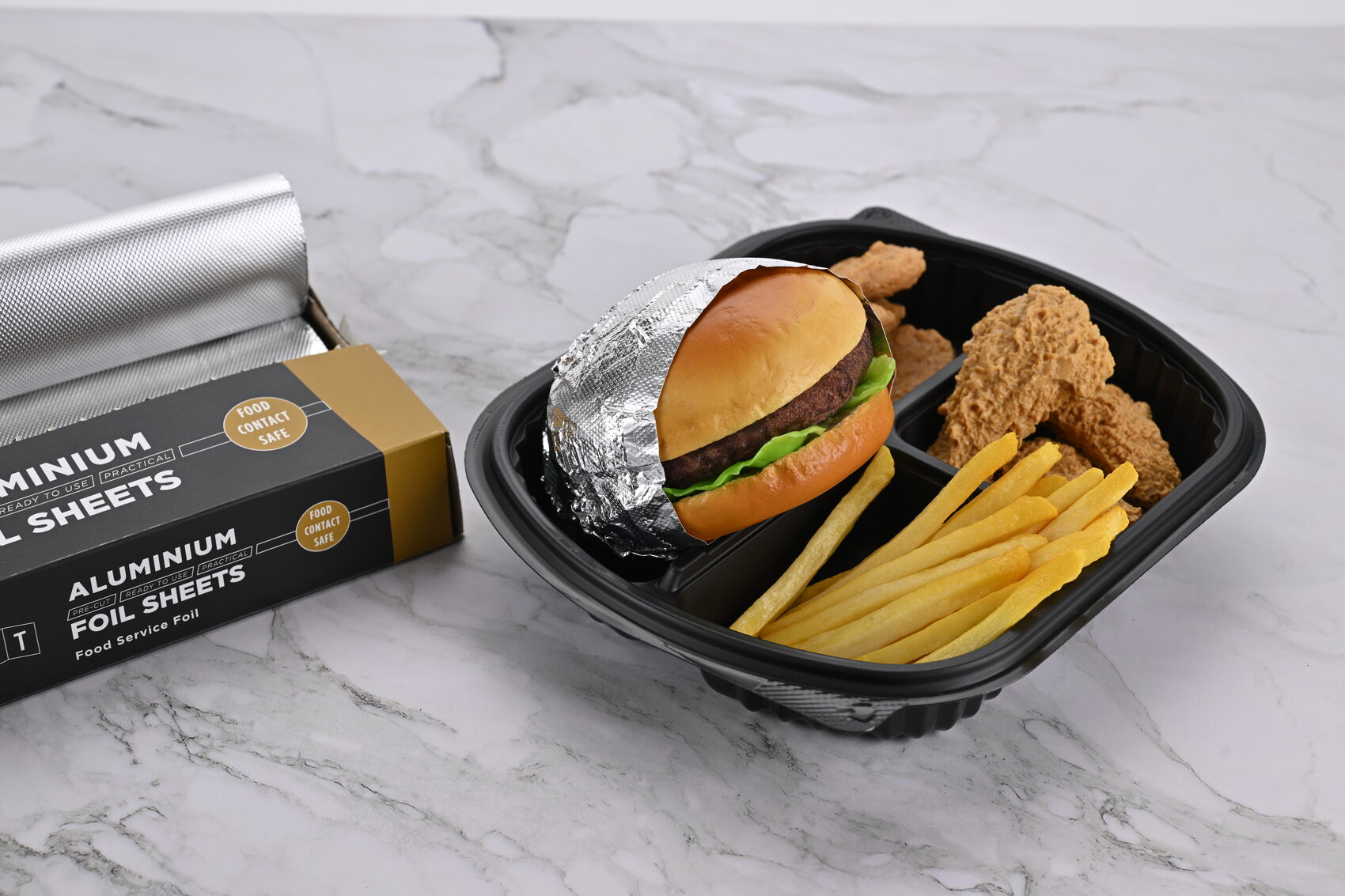 Folyoya sarılı burger, tavuk ve patatesten oluşan menü tabağı